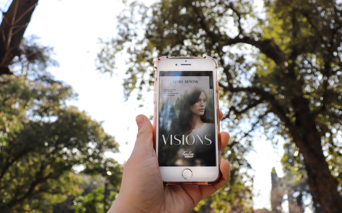 visions de flora armonie en ebook sur un iphone au milieu d'un parc